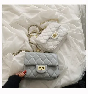 Close-up of quilted chain bags with gold metal ball clasp in white and grey colors
