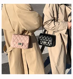 Detailed view of quilted faux leather texture with classic gold metal turn-lock on a handbag