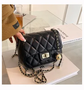 Close-up of black quilted leather bag with gold ball adjuster and metal chain strap
