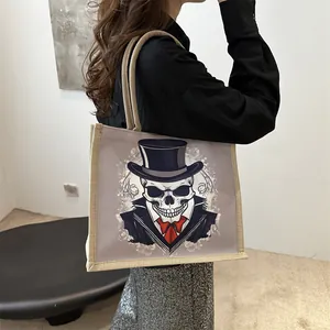 Grey skull print canvas tote bag with braided handles and decorative woven trim