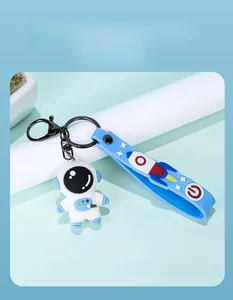 Detailed view of a cute 3D astronaut keychain with a blue rocket silicone strap.