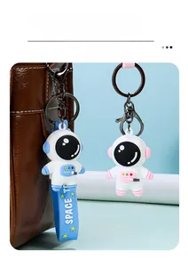 Close-up of cute 3D astronaut keychains in blue and pink finishes with PVC straps
