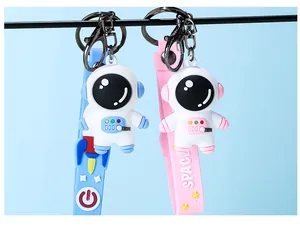 Close-up of cute cartoon astronaut keychains in pink and blue with silicone straps
