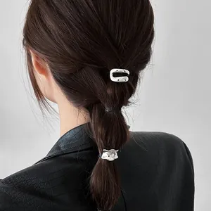 Minimalist silver metallic geometric hair clips shown on a dark braided ponytail