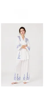Mannequin portant un ensemble de détente blanc avec broderie florale bleue et kimono.