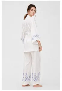 Vue arrière d'un ensemble pyjama en satin blanc avec broderie florale bleue élégante.