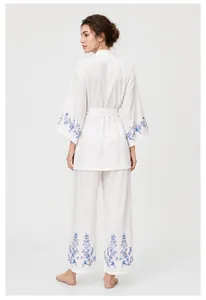 Vue arrière d'un élégant ensemble peignoir et pantalon blanc brodé de fleurs bleues