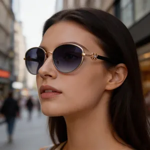 Side view of elegant golden oval sunglasses with a decorative four-leaf clover hinge