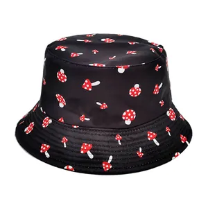 Detailed macro view of a stylish black bucket hat featuring a vibrant red mushroom print.