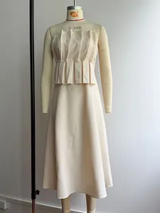 Detail of elegant cream strapless dress with vertical pleats and flared A-line skirt