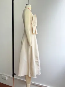 Elegant cream strapless gown featuring detailed French pleated bow on mannequin.