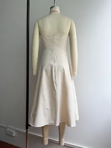 Detailed back view of an elegant cream French style strapless A-line pleated evening dress