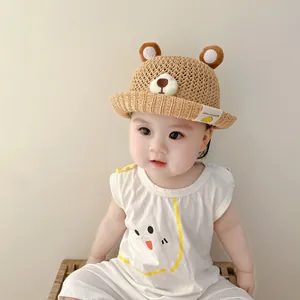 Close-up detail of a breathable baby straw hat with cute bear ears and facial design
