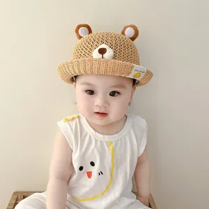 Detail of a baby straw sun hat with cute bear ears and breathable mesh weave.