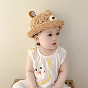 Macro view of a cute baby bear-themed straw sun hat featuring a breathable woven texture.