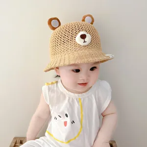 Close-up of an adorable baby wearing a breathable straw sun hat with cute bear ears