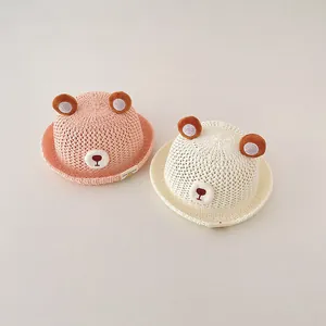 Close-up of adorable pink and cream baby sun straw hats with cute 3D bear ear designs