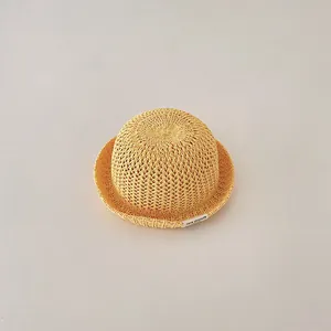 Close-up detail of a breathable yellow woven straw sun hat for infants and toddlers