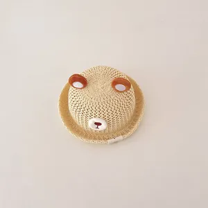 Detail view of a cute woven straw sun hat for toddlers featuring cute 3D bear ears