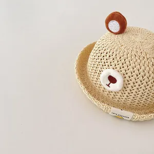Close-up of breathable baby straw sun hat featuring cute bear design and woven texture