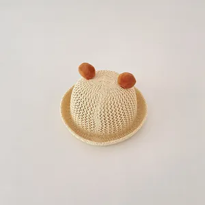 Close-up of baby straw sun hat featuring cute bear ears and breathable woven texture