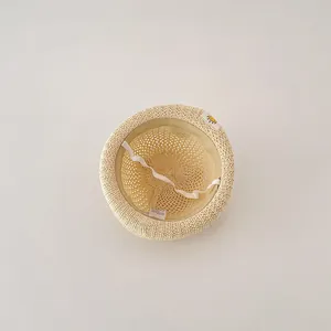 Close-up interior view of breathable beige straw sun hat for infants with white chin strap