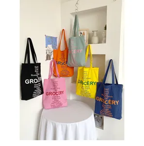 Close-up of colorful canvas tote bags featuring grocery lists in a minimalist interior
