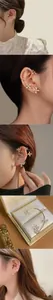 Gros plan de boucles d'oreilles fleurs dorées avec cristaux et perles sur l'oreille