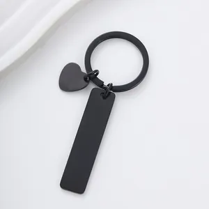 Detail view of matte black stainless steel keychain with heart and bar charms