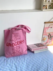 Detail of pink cotton canvas tote bag with red Grocery and vegetable list print