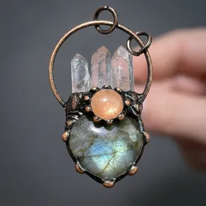 Detailed view of handmade bronze pendant with crystal points and heart labradorite