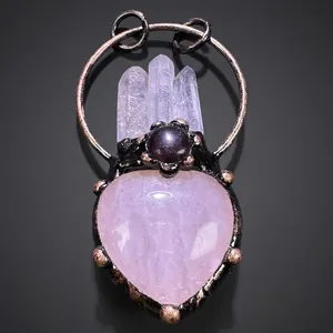 Macro detail of heart-shaped rose quartz pendant with amethyst and crystal points