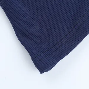 Detail view of navy blue ribbed fabric with double-needle stitching on the hemline