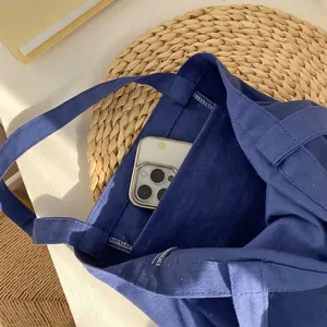 Detail of the internal open pocket of a canvas tote bag showing storage for a phone