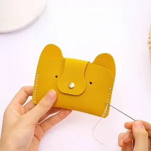 Detail showing hands sewing a yellow PU leather DIY card holder with metal snap