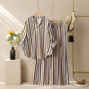 Detail of V-neck striped top and wide-leg pants with yellow and black vertical patterns