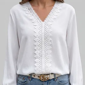 Detail of white V-neck blouse featuring intricate lace embroidery and ruffled cuffs