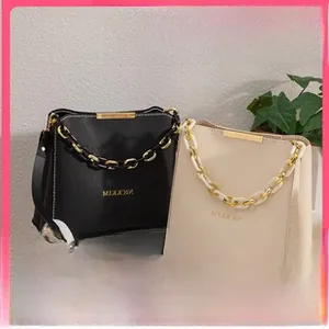 Close-up of DIY coin purse featuring lychee grain leather and gold metal chain strap