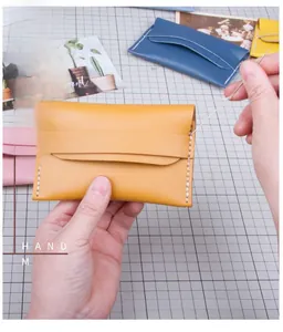 Close-up of hand stitching a yellow leather DIY envelope coin purse material kit