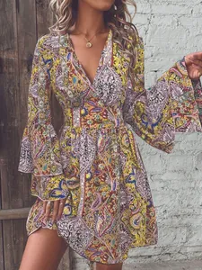 Detail of multi-color paisley dress featuring deep V-neck and tiered bell sleeves