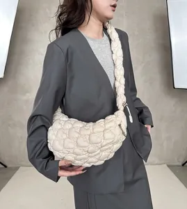 Detail of the cream quilted cloud bag showing the braided strap and nylon texture
