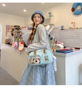 Détail du sac ITA bleu clair avec fenêtre transparente et peluche de chien décorative