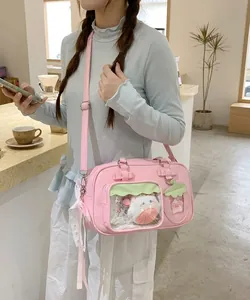 Sac bandoulière ita bag en PU rose avec fenêtre PVC et détail nœud porté par mannequin