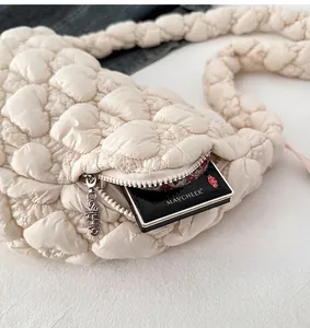 Detail of the side zipper pocket on a quilted cloud bag showing storage for makeup