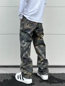 Détail du pantalon cargo camouflage ample avec imprimé forêt réaliste et poches