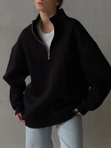 Detail view of a black quarter-zip oversized sweatshirt with drop shoulder and soft fleece lining