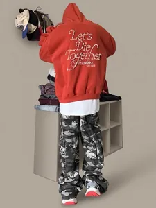 Detailed back view of red hoodie featuring pearl lettering and floral camo trousers