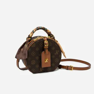 Makroaufnahme der runden Retro-Umhängetasche mit Monogramm-Muster und Schalgriff