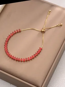 Dettaglio del bracciale con zirconi marquise rossi e chiusura a scorrimento in oro