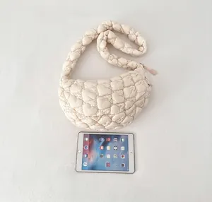 Size comparison of a beige quilted puffer bag next to a tablet on a clean background